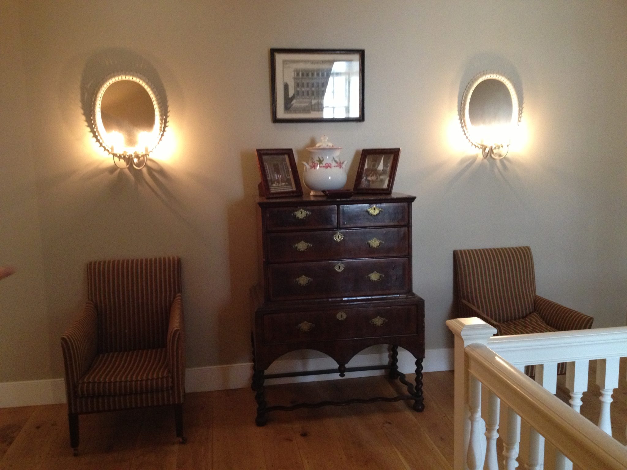 Symmetry on a landing where light tunnels have been used to add natural light and mirrors reflecting wall lights create atmosphere