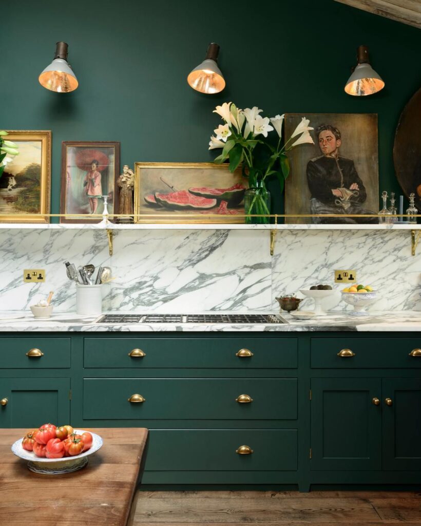Dramatic marble splashback and countertop is striking against the contrast of dark green cabinetry and walls