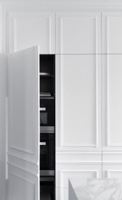 Concealed ovens behind panelled handleless cabinet doors 