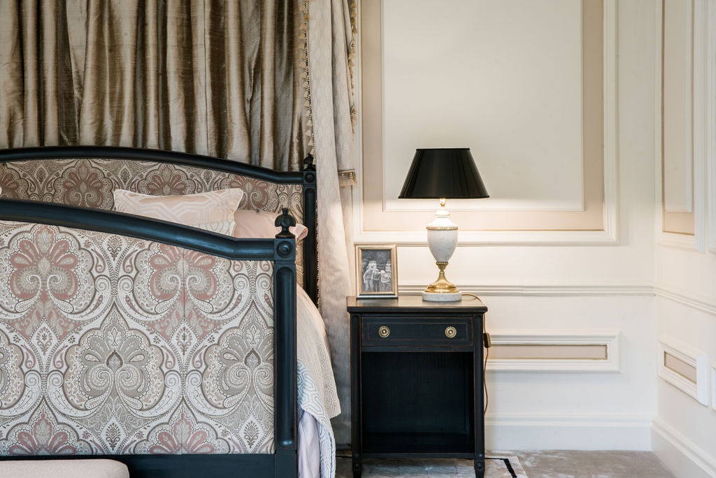 Georgian bedroom with upholstered headboard, pleated curtains and classical wall panelling.