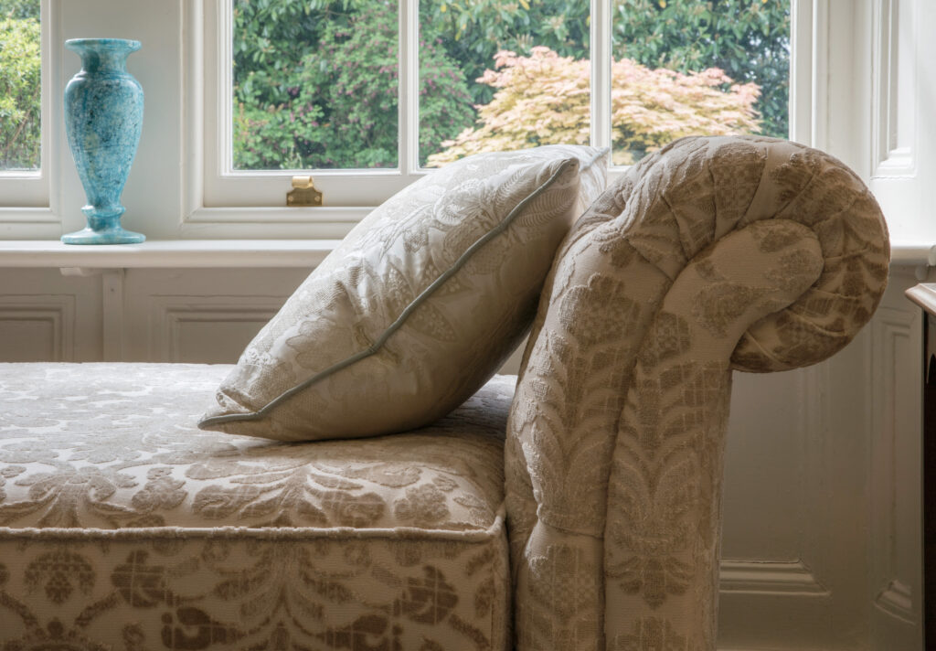 Georgian sitting room with damask upholstered sofa and brass floor lamp.