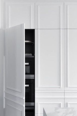 Concealed ovens behind panelled handleless cabinet doors Concealed ovens behind panelled handleless cabinet doors