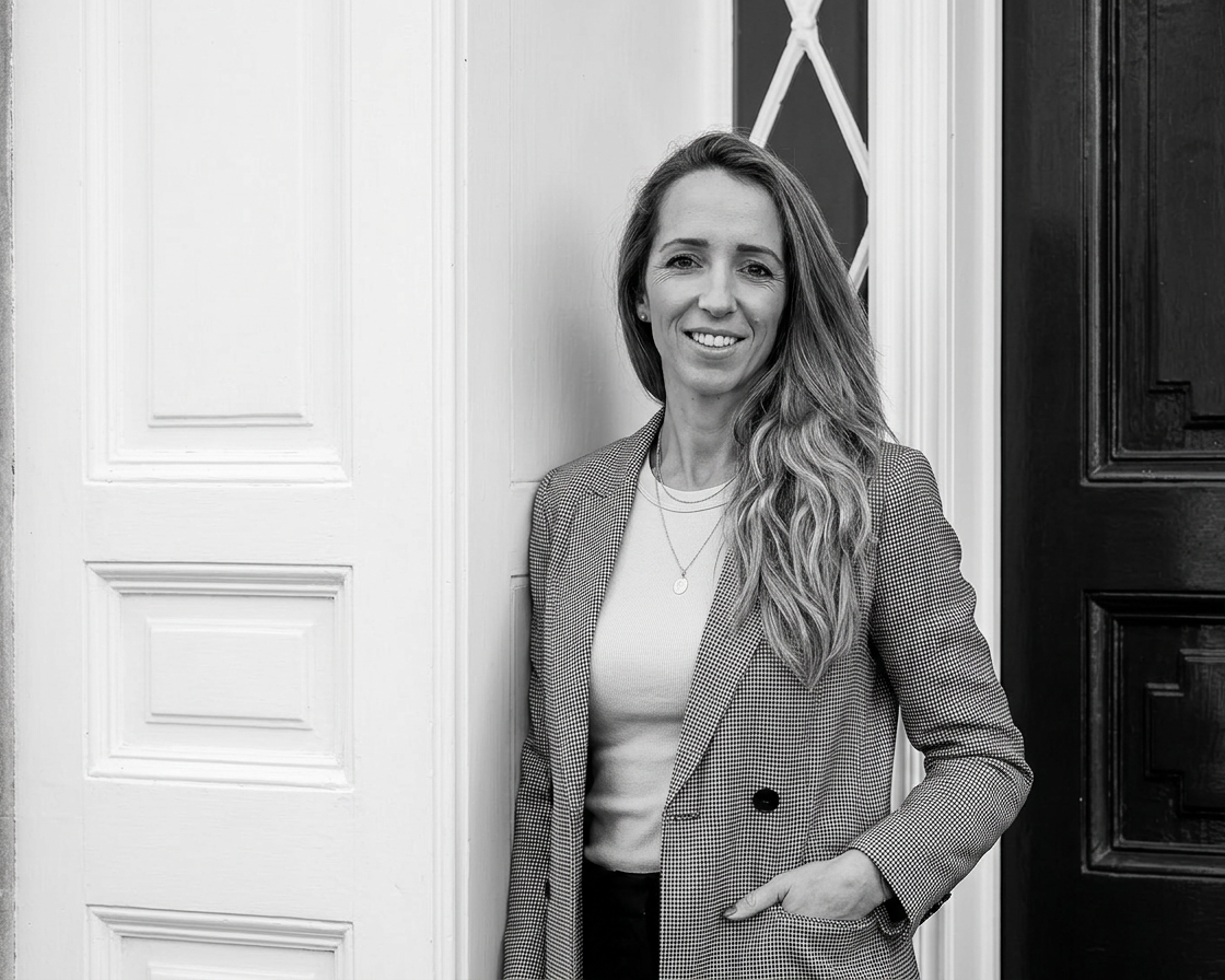 Estelle-Martin-Lyet-meet-the team-Etons-of-bath Black and white portrait photo of Estell Martin Lyet outside the Etons of Bath offices